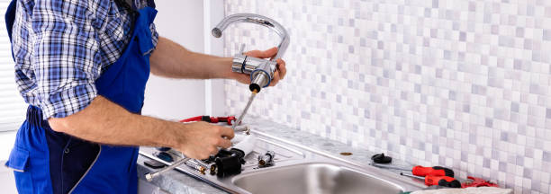 Mid Section Of Male Plumber Assembling The Kitchen Sink Faucet