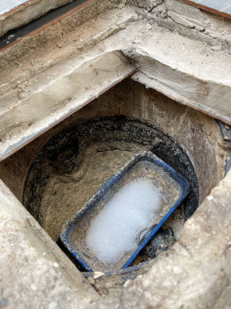 Grease trap plastic box with fatty water floating on top and chemical bubble.