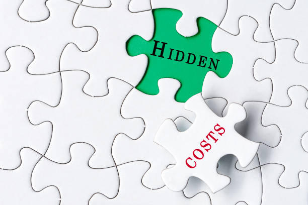 White jigsaw puzzle with word hidden costs over green background. Costing concept.