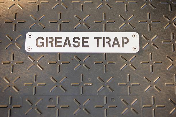 Close up photograph of stenciled metal great trap sign on metal cover on ground floor plate. Plate has cross and plus sign pattern.
