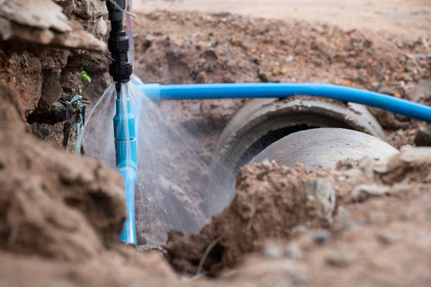Water pipe break .Exposing a burst water main, focused on the spraying water and the pipe.